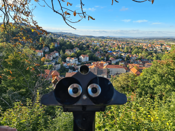 Blick durch ein Fernrohr auf die Stadt Blaneknburg und das Harzvorland