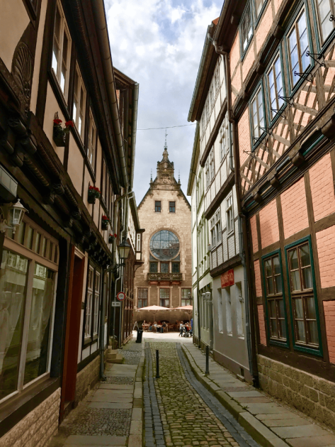 Enge Gasse mit Fachwerk, Kopfsteinpflaster und Kirche in Quedlinburg