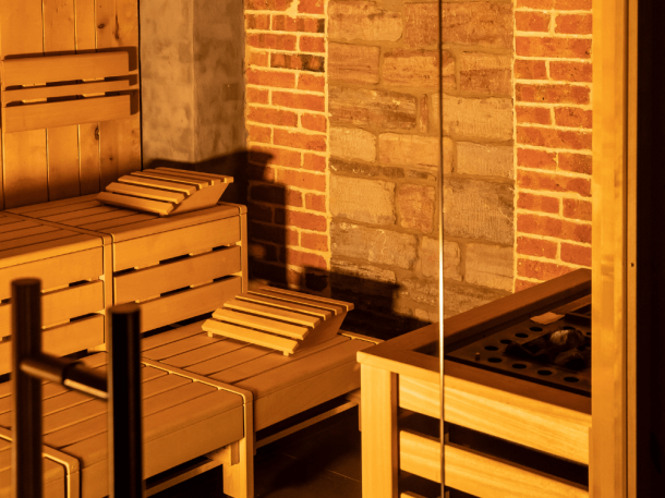Sauna von innen mit Holzbänken und Aufguss-Station