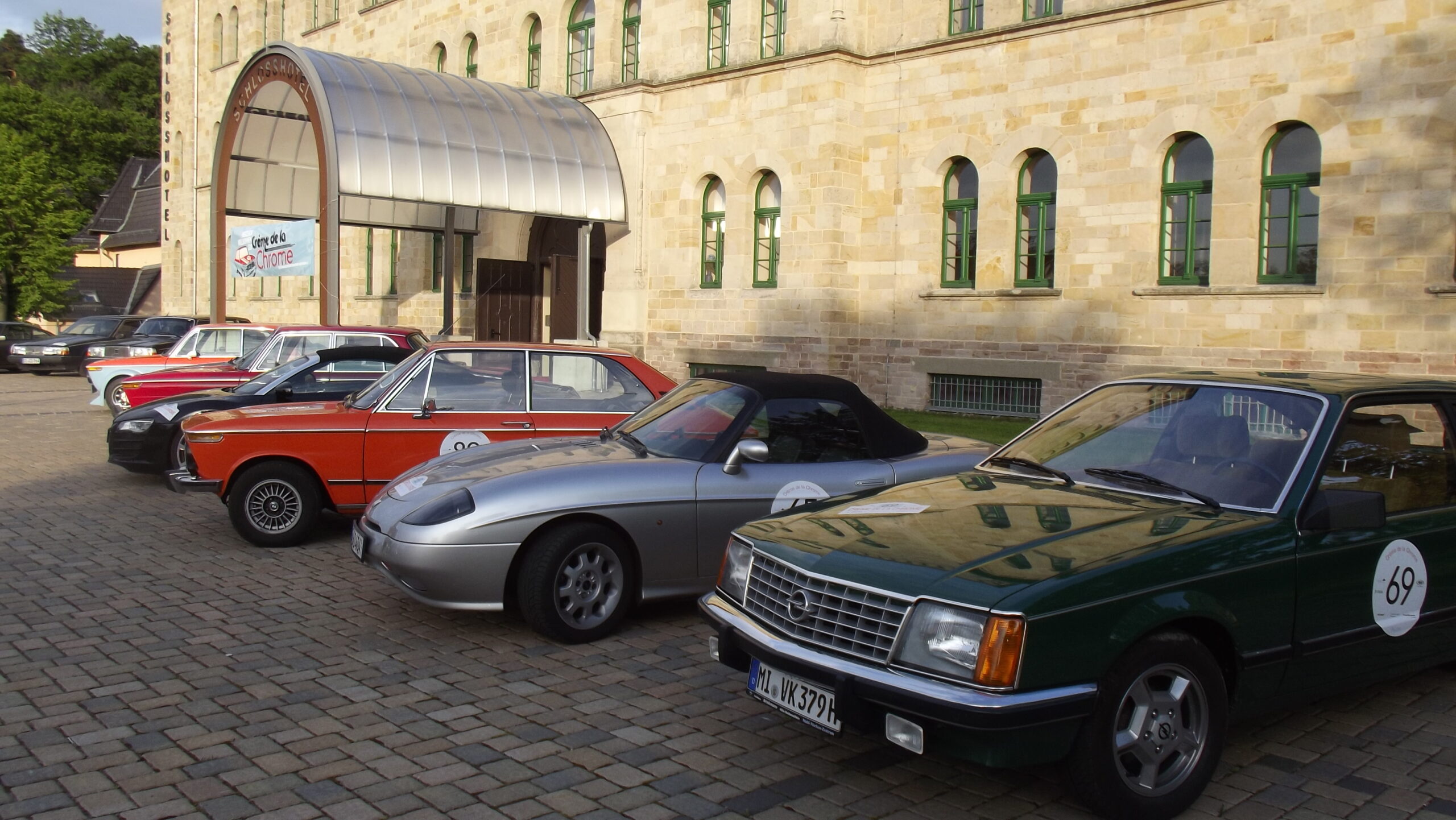 Oldtimer stehen vor dem Schlosshotel Blankenburg geparkt