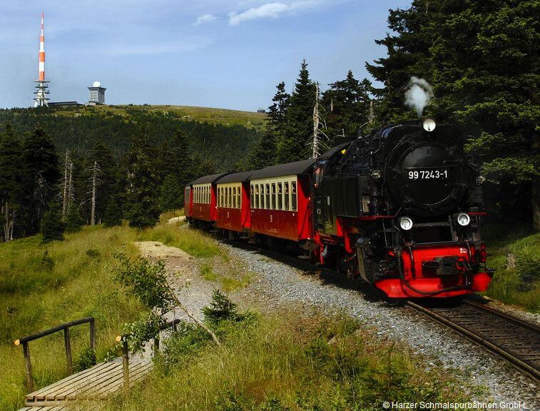 Historische Brockenbahn mit Brockengipfel im Hintergrund