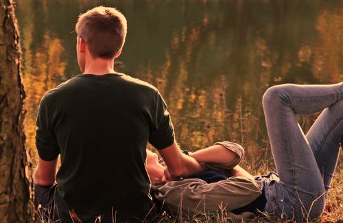 Paar auf einer Wiese sitzend und liegend