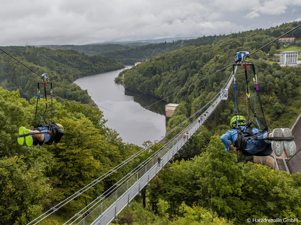 Zwei Personen an der Zipline hinunter ins Tal an der Rappbodetalsperre im Harz