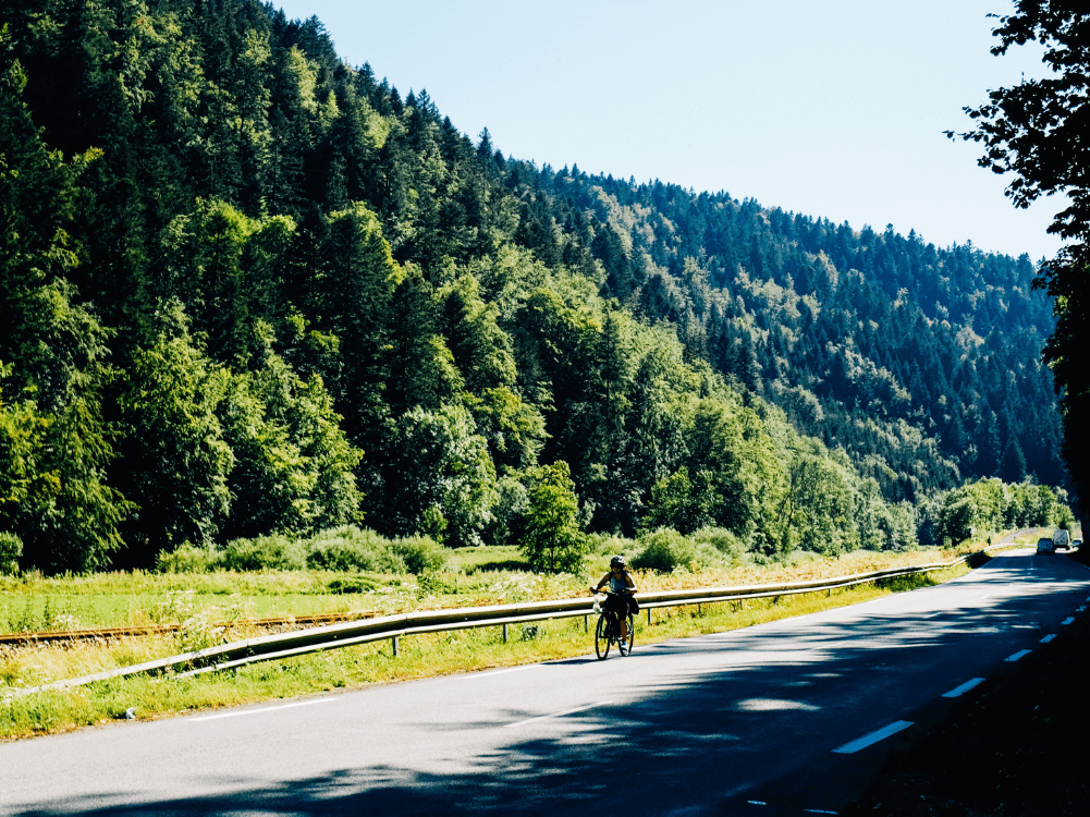 Radfahrer vor Bergen auf einer ruhigen Straße