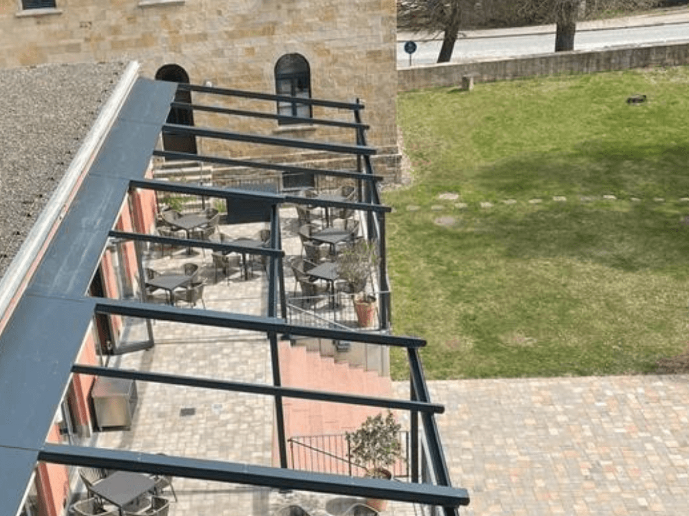 Heutiger Anblick auf die Terrasse mit Überdachung und Tischen