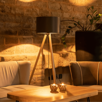 Sofa mit Sessel, Tisch und Stehlampe in der Lobbybar