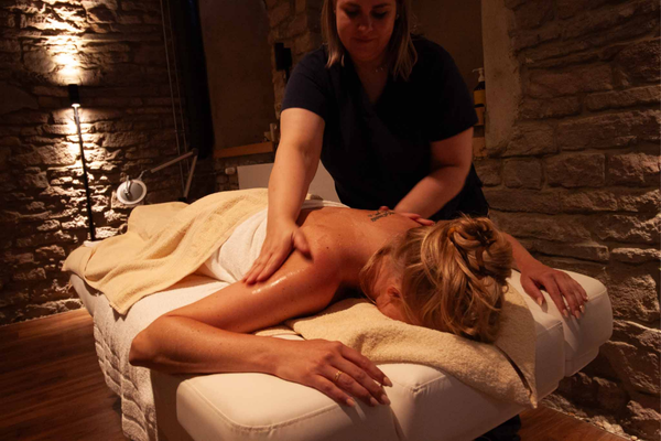 Massageliege und gemütlich gestalteter Wellness Raum