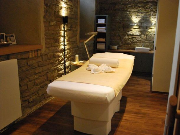 Massageliege und gemütlich gestalteter Wellnessraum