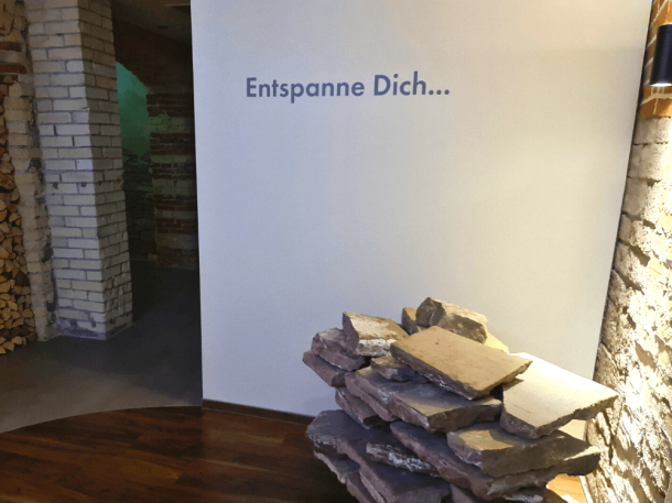 Wellnessbereich mit Kunstobjekt und Wandschrift Entspanne dich