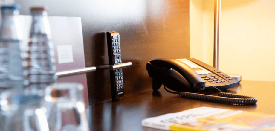 Schreibtisch mit Getränken, Zeitschrift, Telefon und Lampe