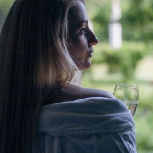 Frau schaut verträumt aus dem Fenster